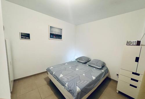 une chambre avec un lit et deux tableaux au mur dans l'établissement appartement hyeres centre, à Hyères