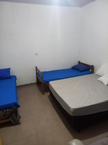 two beds in a room with blue and white at Ar condicionado ! Pousada familiar natureza Rustic in Ilha Comprida