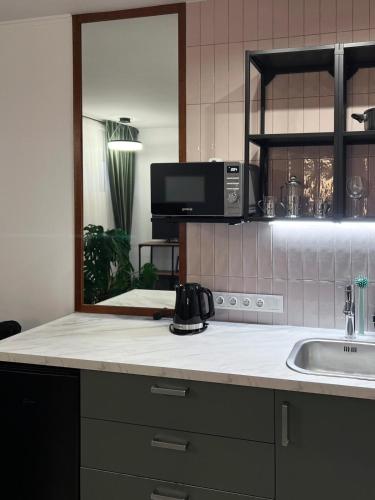 a kitchen counter with a sink and a microwave at Cozy V&S apartment with two bedrooms in Choszczówka