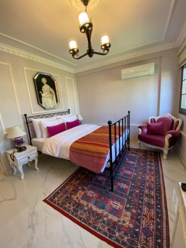 a bedroom with a bed and a chair and a rug at Villa Ephesus Hotel in Kusadası