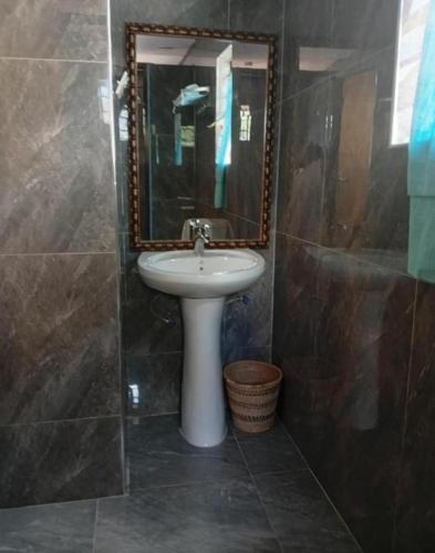 a bathroom with a sink and a mirror at Capricorn by Quest-Cape Maclear in Monkey Bay