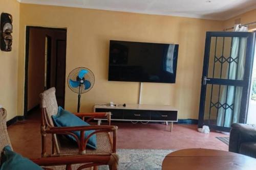 a living room with a flat screen tv on the wall at Capricorn by Quest-Cape Maclear in Monkey Bay