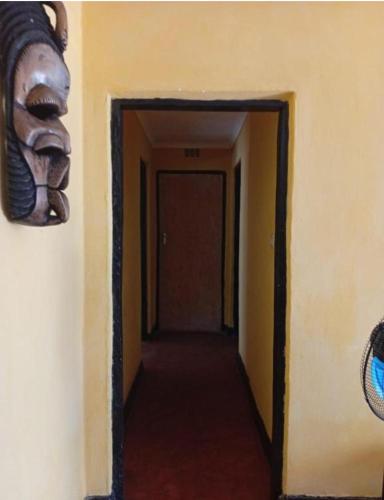 a hallway with a mask hanging on a wall at Capricorn by Quest-Cape Maclear in Monkey Bay