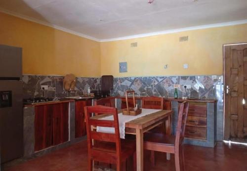 a kitchen with a table and chairs in a room at Capricorn by Quest-Cape Maclear in Monkey Bay