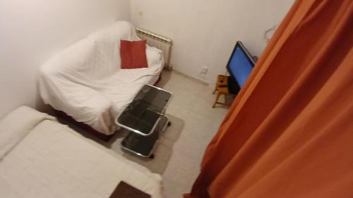 a small bedroom with a bed and a television at Double Room with Air Conditioning in Toledo in Toledo