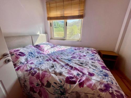 a bed with a floral comforter in a bedroom at Stani i Metes-Bujtina Sebisht in Sebisht