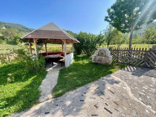 a wooden gazebo with a grave in a field at Stani i Metes-Bujtina Sebisht in Sebisht