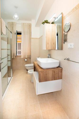 a bathroom with a sink and a toilet and a mirror at Casa Donna Celestina in Letojanni