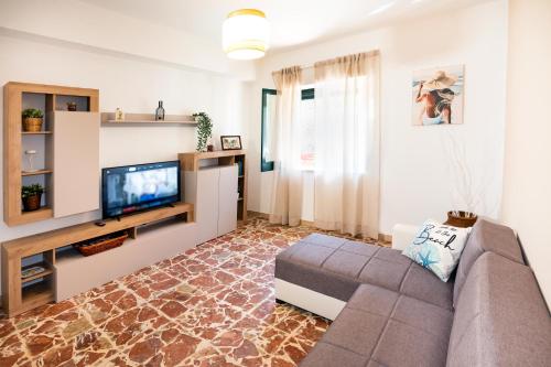 a living room with a couch and a tv at Casa Donna Celestina in Letojanni