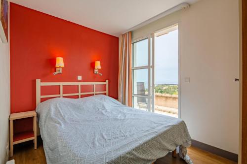 une chambre avec un lit et une grande fenêtre dans l'établissement Résidence le Village de Cap Esterel - maeva Home - Appartement duplex 2 pièces 6 personnes avec coin cabine - Sélection MAE-6809, à Saint-Raphaël