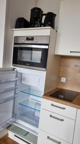 a kitchen with an open refrigerator with a stove at Optimist Sunlife Ostsee in Wendtorf