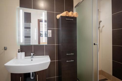 a bathroom with a sink and a shower with a mirror at Apartment Eric,High Tatras in Vysoké Tatry