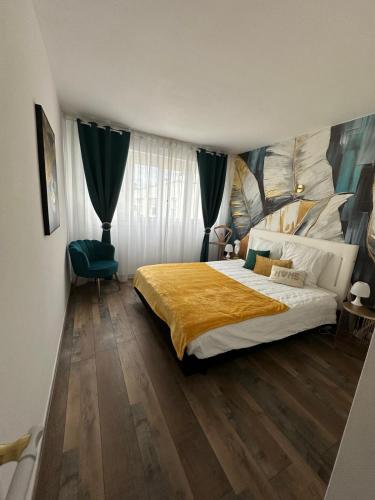 une chambre avec un grand lit et une chaise verte dans l'établissement Appartement moderne confortable, à Blois