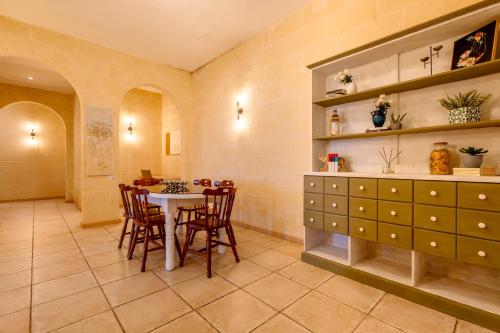 a kitchen and dining room with a table and chairs at Zest Holiday Home in Qala