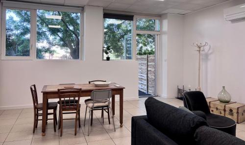 un salon avec une table et des chaises en bois dans l'établissement Appartement T2 à proximité du Salagou, à Clermont-lʼHérault