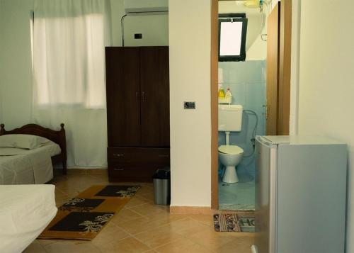 a bathroom with a toilet and a sink in a room at Morina Rooms in Durrës