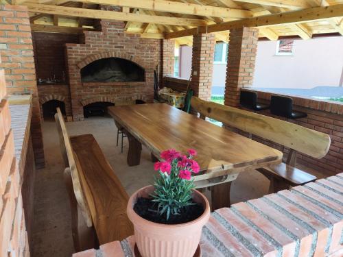 a dining room with a table and a brick fireplace at Oaza mira Šipovo in Šipovo