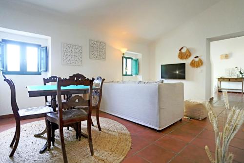 a living room with a table and chairs at Tapada da Figueira by NaturAlegre in Esperança
