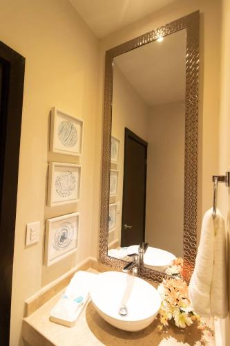 a bathroom with a sink and a large mirror at RayoDeSol Condo10min to Beach,Gym,Pool,WIFI 200MB in Playa del Carmen