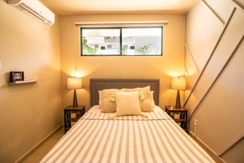 a small bedroom with a bed with a window at RayoDeSol Condo10min to Beach,Gym,Pool,WIFI 200MB in Playa del Carmen