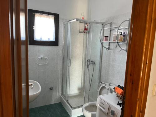 a bathroom with a shower and a toilet and a sink at Villa Nefeli in Ayios Nikolaos Sithonia