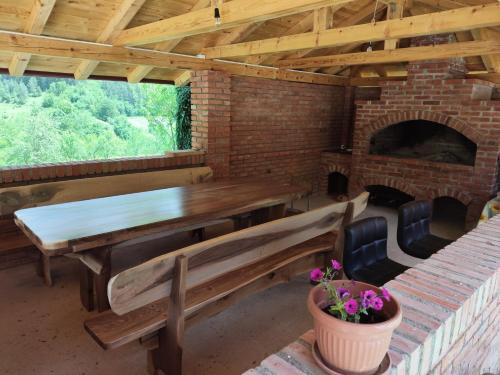 a dining room with benches and a brick fireplace at Oaza mira Šipovo in Šipovo