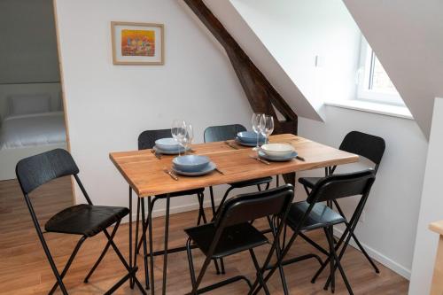 - une table à manger avec des chaises et des verres à vin dans l'établissement Exceptional apartment in a manor house, à Aire-sur-la-Lys
