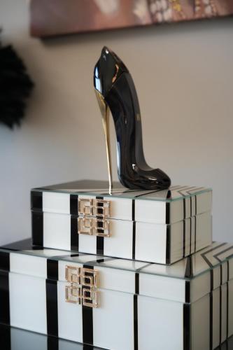 a black and white table with a high heel shoe on top of books at Artion Suites Nikiti in Nikiti