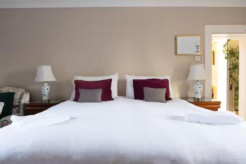 a bedroom with a large white bed with red pillows at Fitz Of Inch in Stradbally