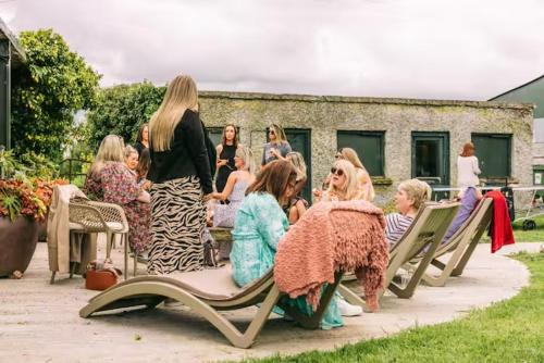 a group of people sitting on park benches at Fitz Of Inch in Stradbally