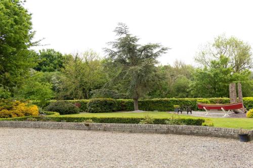 a park with a bench and a tree at Fitz Of Inch in Stradbally