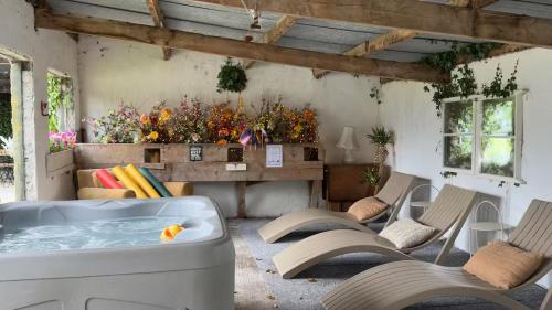 a room with a hot tub and chairs and a table at Fitz Of Inch in Stradbally