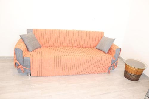 a couch with three pillows on it in a room at Appartamento D&G in Vico del Gargano