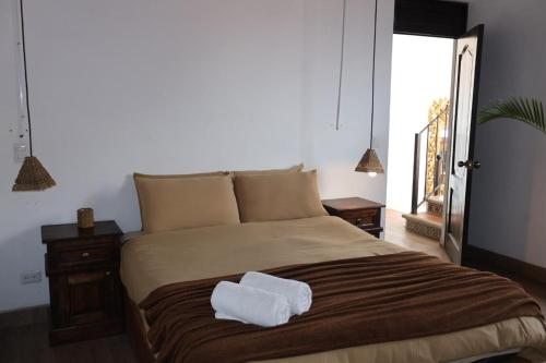 a bedroom with a large bed with two towels on it at Tauro in Antigua Guatemala