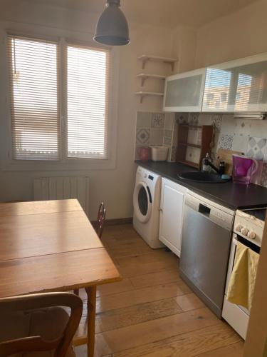 une cuisine avec une table et un comptoir dans l'établissement Orus Corner - plage à 5 minutes à pied, à Marseille