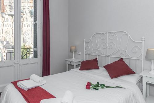 バルセロナにあるウォッチング サグラダ ファミリアの白いベッド(赤い枕、バラ付)