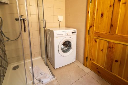 a bathroom with a washing machine and a shower at Nadurin Holiday Home in Nadur