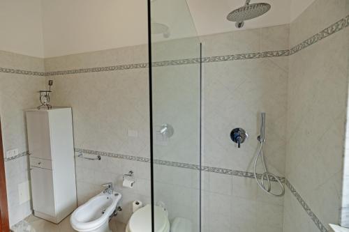 a bathroom with a shower and a toilet and a sink at Casa Vacanze Leonardo 2 in Roccella Ionica