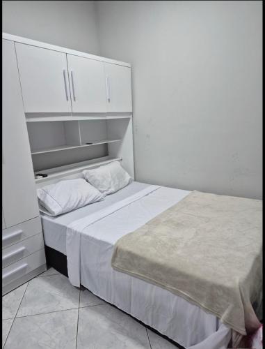 a small bedroom with a bed and white cabinets at Casa Studio 1 Quarto in São José dos Campos