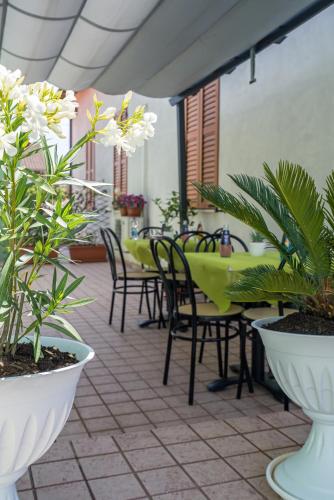 a patio with tables and chairs and plants at Rooms & Breakfast Centrale in Fabriano