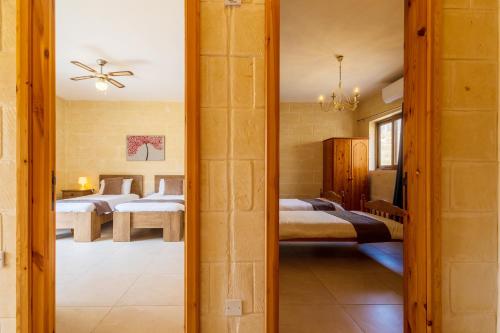 a bedroom with two beds and a mirror at Nadurin Holiday Home in Nadur