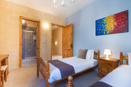 a bedroom with two beds and a bathroom at Nadurin Holiday Home in Nadur