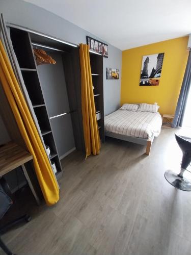 - une chambre avec un lit et des rideaux jaunes dans l'établissement Studio Gabin, à Niort