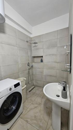 a bathroom with a washing machine and a sink at Near the beach, Blue Mirage Apartment in Orikum