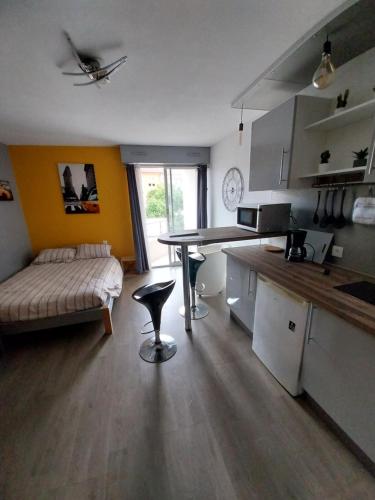 - une cuisine avec une table et un canapé dans une chambre dans l'établissement Studio Gabin, à Niort