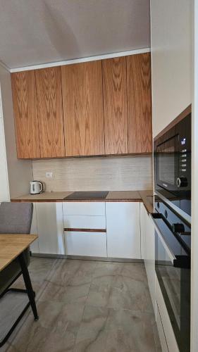 a kitchen with wooden cabinets and a stove top oven at Near the beach, Blue Mirage Apartment in Orikum