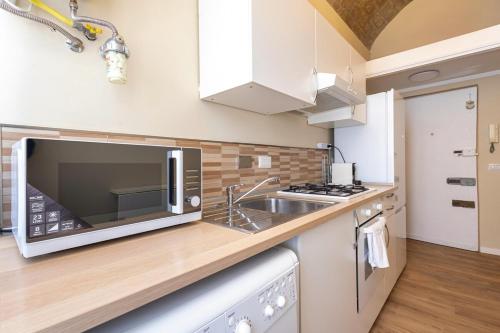 a kitchen with a microwave and a sink at The Heartbeat of Bohemian Rome in Rome