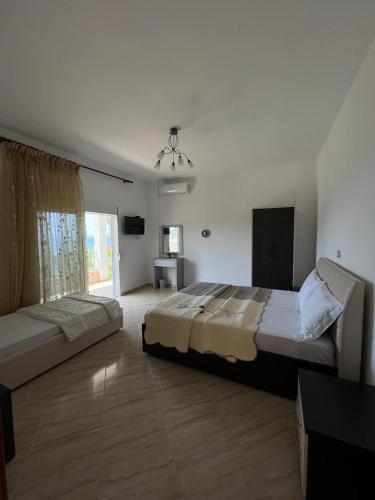 a large bedroom with two beds and a window at Vila Alexandros in Qeparo
