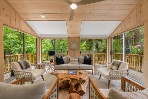 a screened in porch with a couch and chairs at Treehouse Oasis in New Buffalo