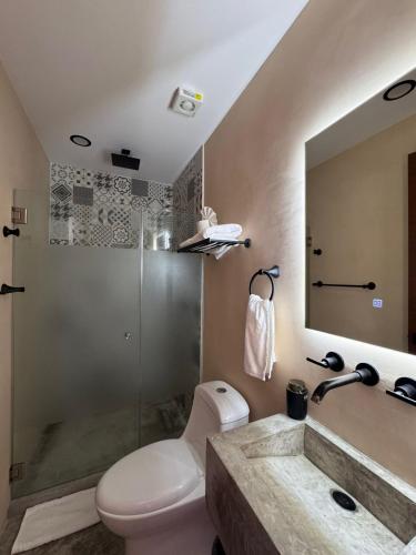 a bathroom with a toilet and a sink and a shower at Kauil Tulum in Tulum
